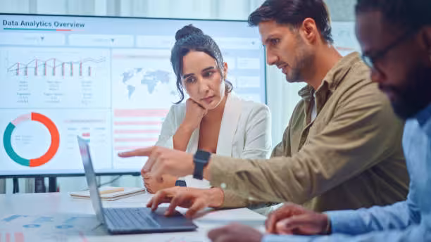 People looking at laptop with data.